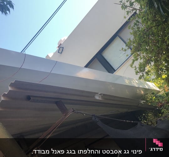 גג מתכת עם קורות תומכות ועצים מסביב